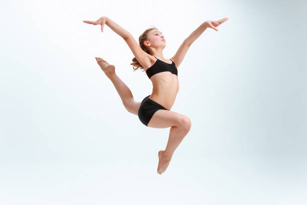 The girl jumping as modern ballet dancer The girl jumping as modern ballet dancer at studio acrobatic gymnastics stock pictures, royalty-free photos & images