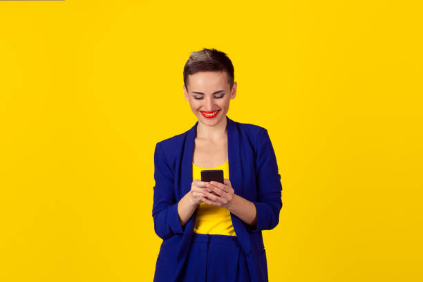 istock Happy young woman holding using new smartphone connected browsing internet worldwide isolated on yellow wall background. 4g data plan provider 682305028