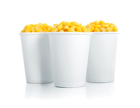 Boiled corn kernels in white paper cups isolated on white