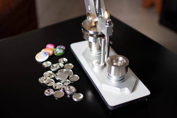 Pins press machine with empty pins and ready pins. Press button maker for 2,5 cm badge.