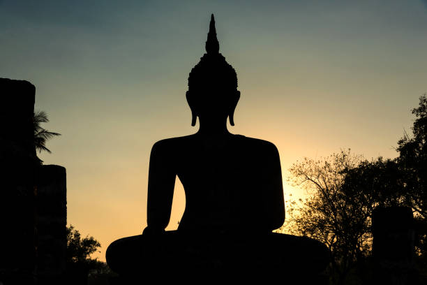 The dark shape of the Buddha statue in the Sukhothai, the first capital of the  Kingdom of Siam in the 13th and 14th centuries.