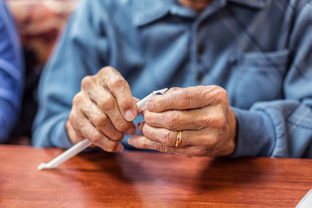 istock Elderly Man Hands Unwrapping Drinking Straw Paper Wrapper 682315776