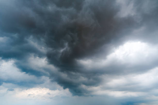 istock black sky Background of dark clouds before a thunder. sunlight through very dark clouds background of dark storm clouds 682316324