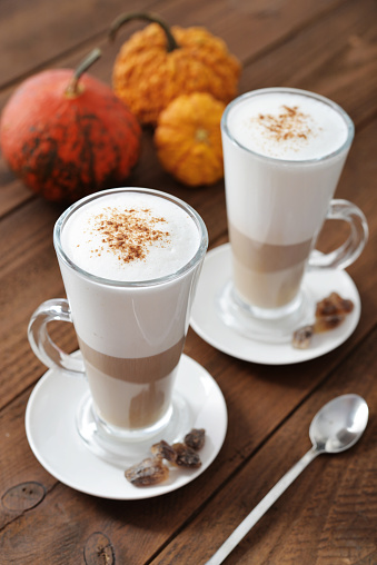 Pumpkin spice latte with cinnamon and decorative pumpkins