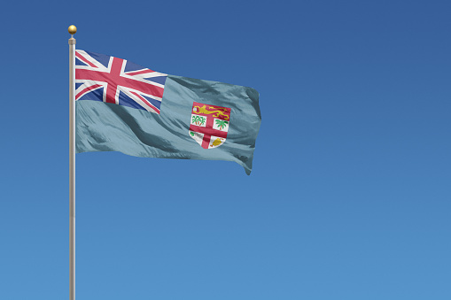 Flag of Fiji in front of a clear blue sky
