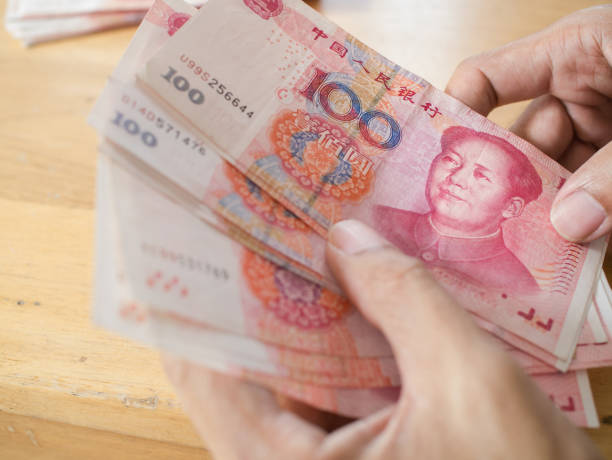 istock Man hand counting Chinese Yuan bank notes currency 682323058