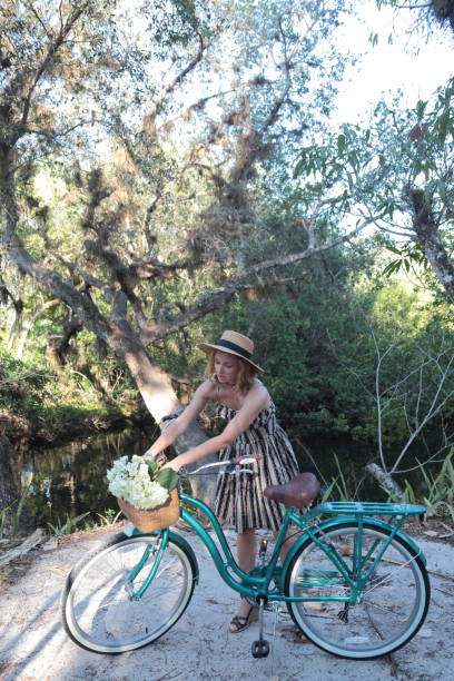 Woman riding bicycle in a tropical park.