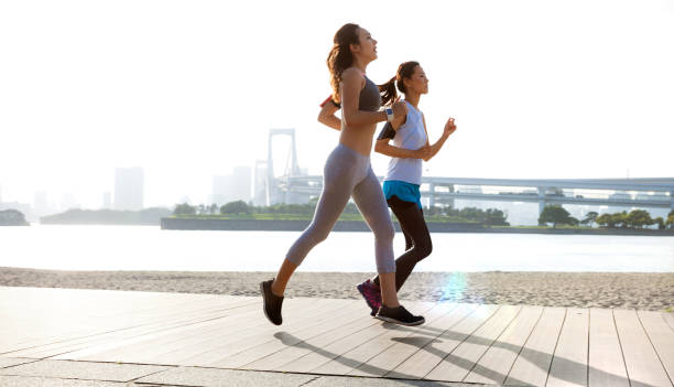 donne in forma che si corrono dopo il lavoro a tokyo - running jogging asian ethnicity women foto e immagini stock