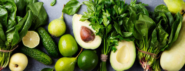 istock Green vegetables and herbs assortment on a grey stone background. Top view. Copy space 682339900