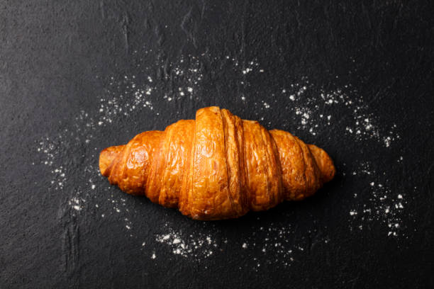 istock Fresh croissant on a black slate background. Top view. Copy space 682341846