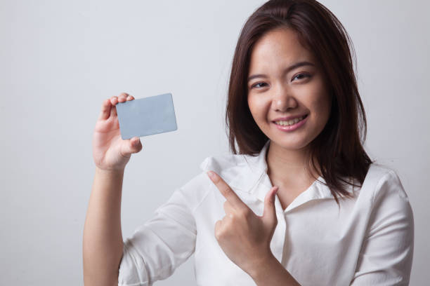 istock Young Asian woman point to a blank card. 682343070