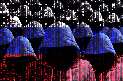 Grupo de hackers con capucha brillando a través de una bandera rusa digital photo