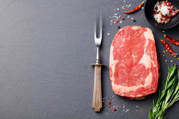 istock Raw beef steak with spices and ingredients for cooking. Top view. Copy space. 682346160