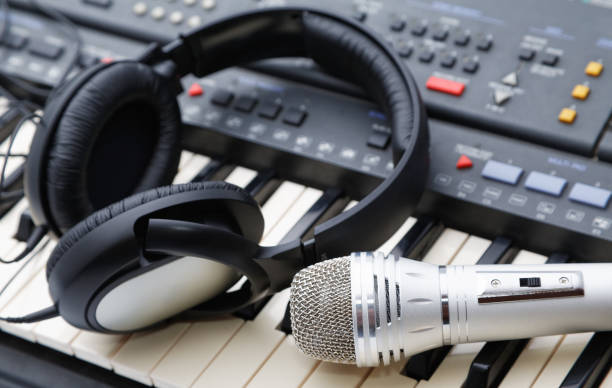 istock microphone and ear-phones lie on the keyboard 682349212