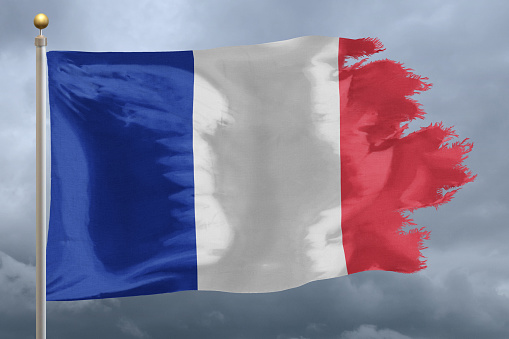 Flag of France tattered and torn with stormy sky