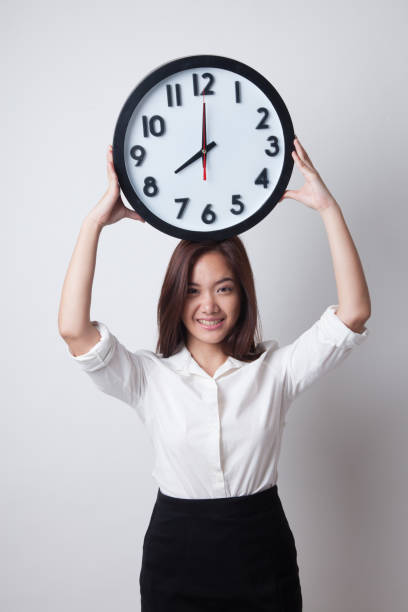 istock Young Asian business woman with a clock. 682360240