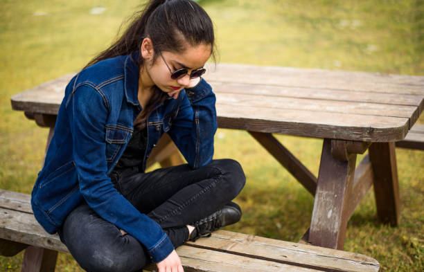 istock Unhappy girl sitting at picnic table 682360738