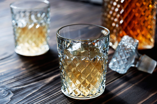 Crystal Decanter. Crystal glasses. Brandy, cognac whiskey with ice closeup