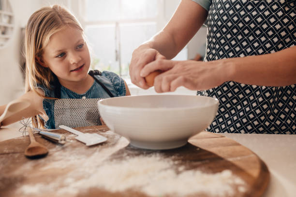 istock Mother and daughter preparing dough for baking 682377106