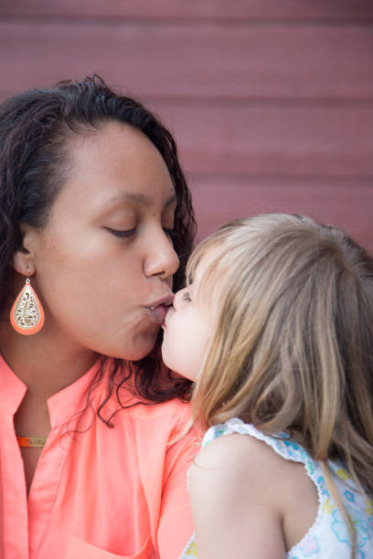 istock Mother kissing child. 682382090
