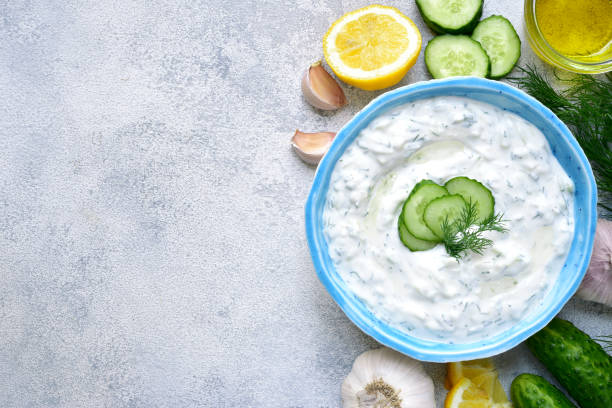 Tzatziki - yoghurt sauce with cucumber and dill Tzatziki - yoghurt sauce with cucumber and dill on a light slate or stone background,traditional greek cuisine.Top view with copy space. tzatziki stock pictures, royalty-free photos & images