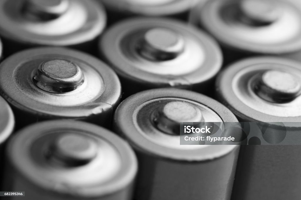 closeup of electric batteries low angle black and white close up of electric batteries and accumulators AAA AA with selective focus on top Battery Stock Photo