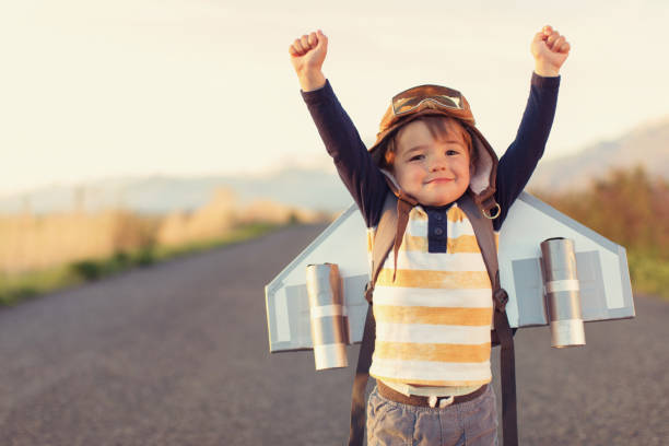 Young Boy with Jet Pack with Arms Raised stock photo