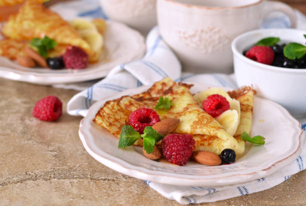 istock Homemade crepes with maple syrup and berries on a concrete background. 682406834