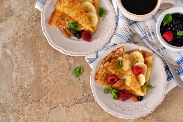 istock Homemade crepes with maple syrup and berries on a concrete background. 682406868