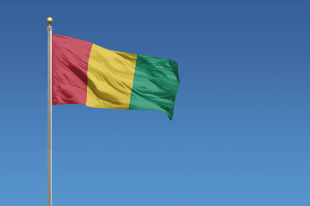 Flag of Guinea in front of a clear blue sky