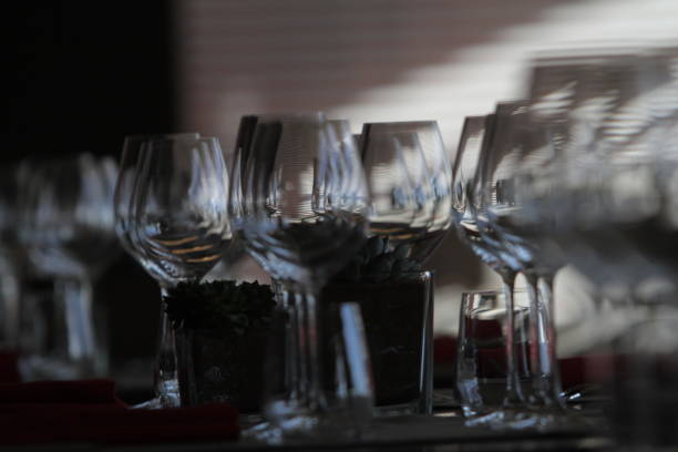 istock Sun light illuminates a wooden table full of empty glasses and white candles 682409426