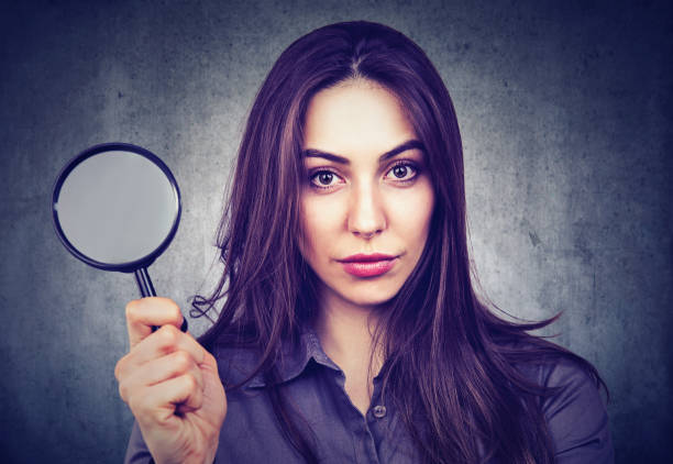 istock Beautiful woman with magnifying glass 682419406