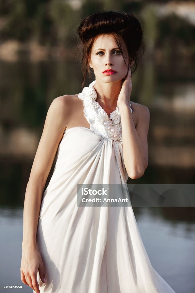 girl on a riverside in summer in beautiful nature Adult Stock Photo