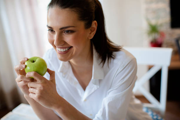istock Woman eating green apple 682424310