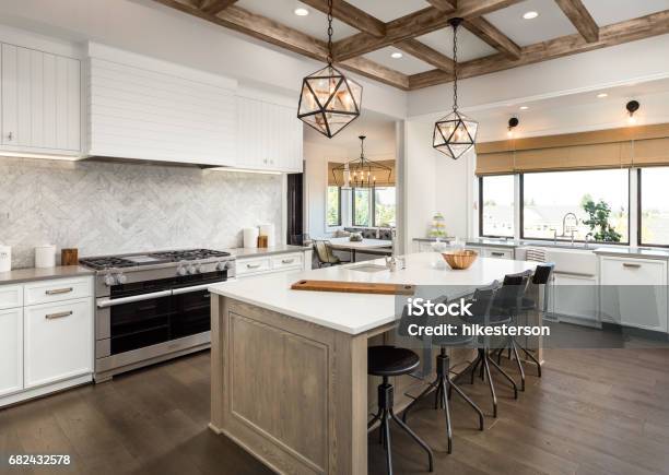 Beautiful Kitchen In New Luxury Home With Island And Pendant Light Fixtures Stock Photo - Download Image Now