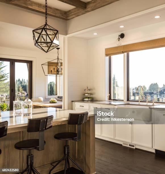 Beautiful Dining Room And Kitchen In New Luxury Home With Island And Pendant Light Fixtures Stock Photo - Download Image Now