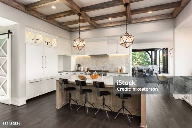 Beautiful Kitchen In New Luxury Home With Island And Pendant Light Fixtures Stock Photo - Download Image Now