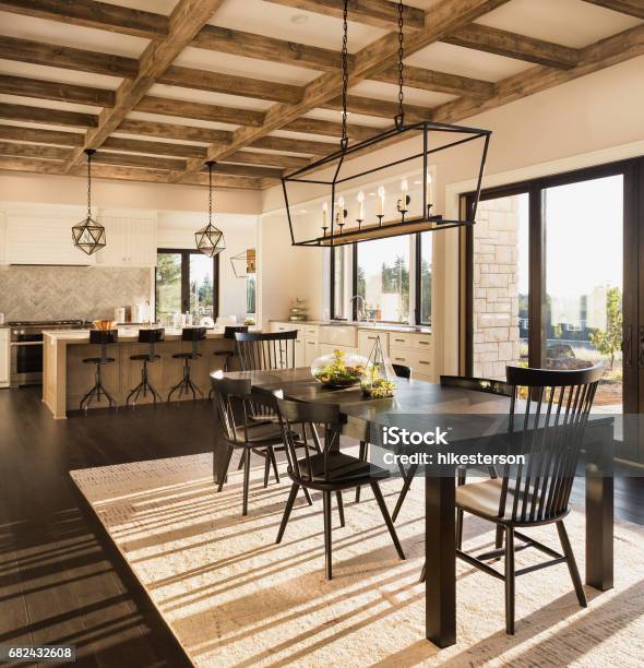 Beautiful Dining Room And Kitchen In New Luxury Home With Island And Pendant Light Fixtures Stock Photo - Download Image Now