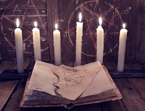istock Magic book with pentagram and evil candles for occult ritual 682443374