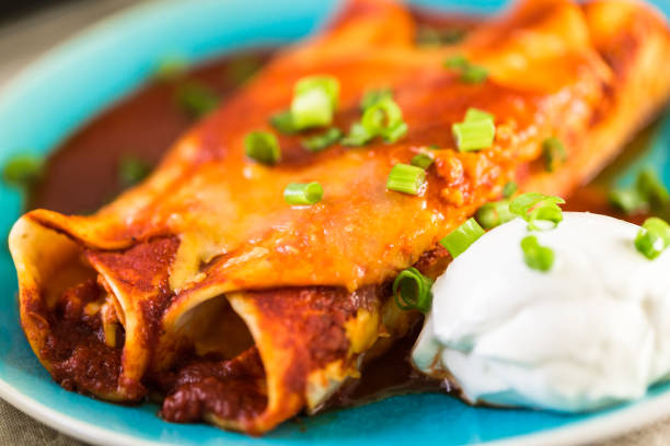 istock Close up of dinner plate with Chicken enchiladas garnished 682454946
