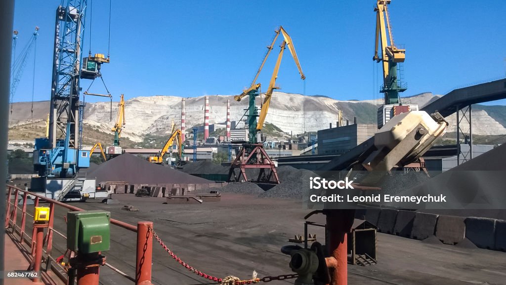 Cargo industrial port, port cranes. Loading of anthracite. Transportation of coal. Heap of coal Cargo industrial port, port cranes. Loading of anthracite. Transportation of coal. Heap of coal. Mining - Natural Resources Stock Photo