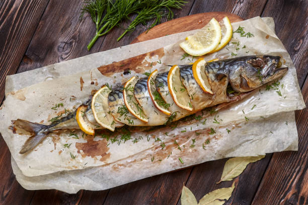 istock Whole baked mackerel or scomber fish with lemon on paper 682467936