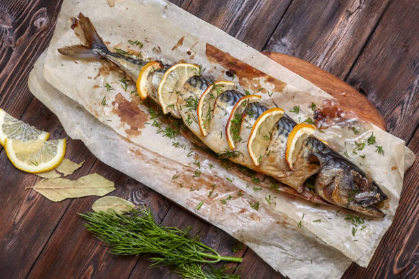 istock Whole baked mackerel or scomber fish with lemon on paper 682467958