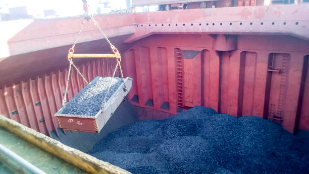the cargo compartment of the ship, filled with coal. loading of - coal crane transportation cargo container imagens e fotografias de stock