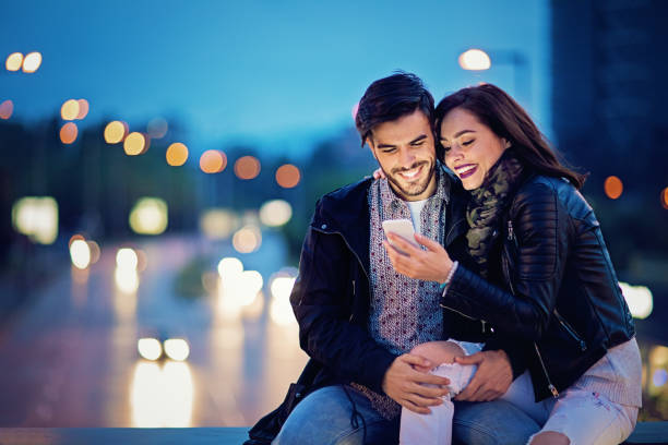istock Couple is texting on the bridge in the night 682482132