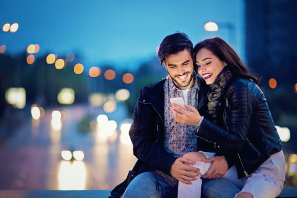 Couple is texting on the bridge in the night stock photo