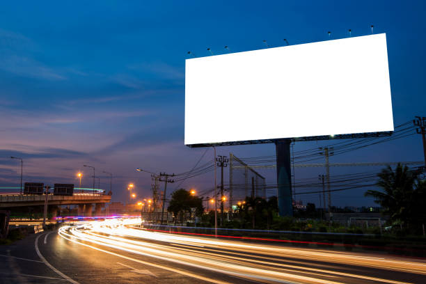 istock Blank billboard for advertisement at twilight time with light trails on the road at dusk 682488696