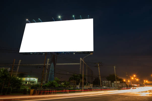 istock Blank billboard for advertisement at twilight time with light trails on the road at dusk 682488702