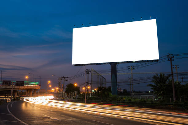 istock Blank billboard for advertisement at twilight time with light trails on the road at dusk 682488704