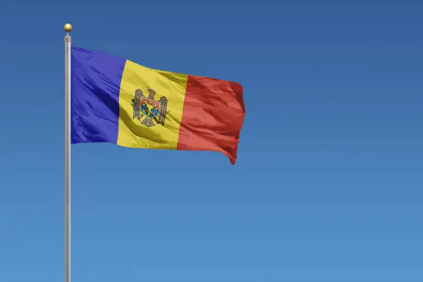 Flag of Moldova in front of a clear blue sky